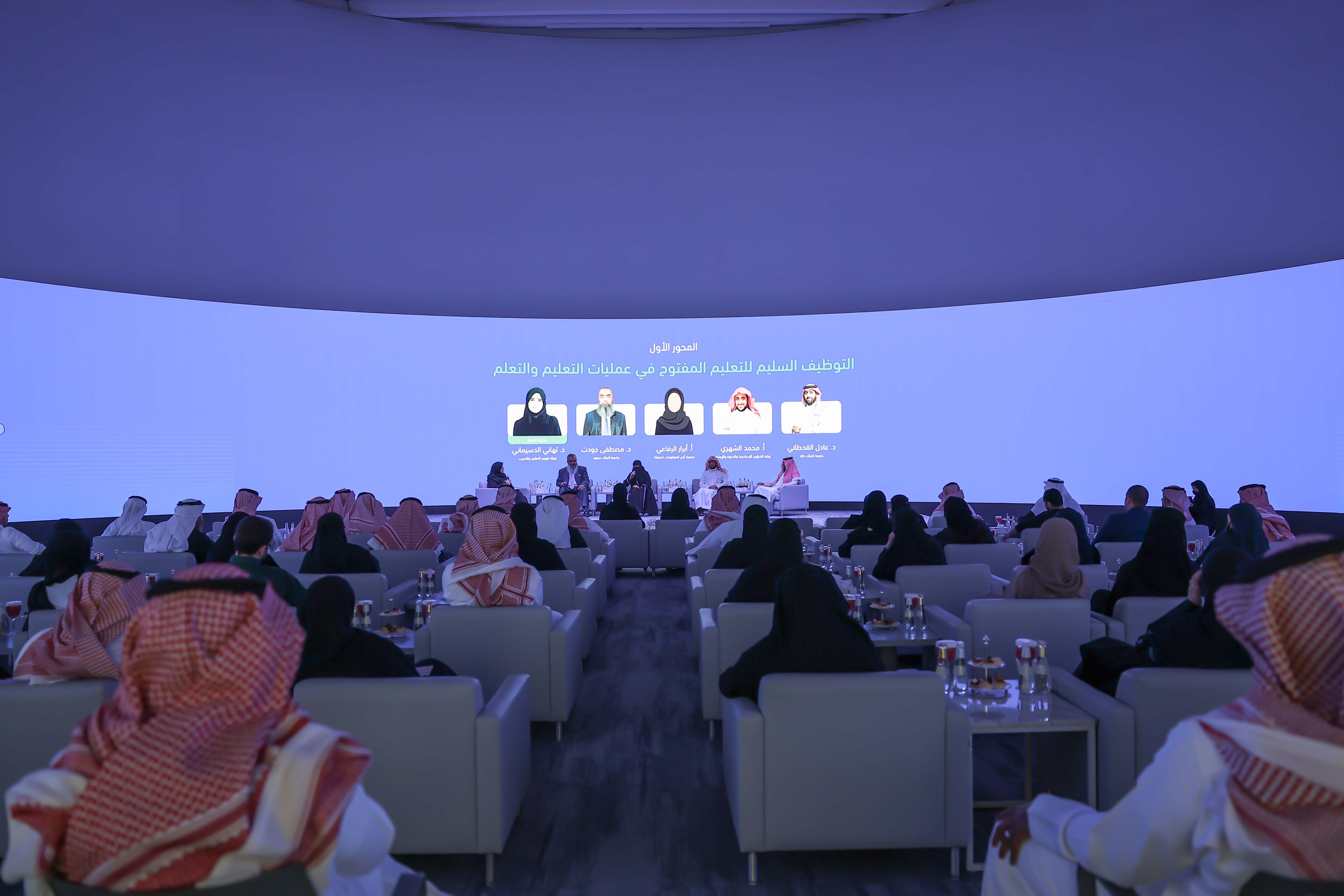 صورة من احتفاء المركز بالأسبوع العالمي للتعليم المفتوح، تعكس عدد من الحضور أمام 5 من المتحدثين، إلى جانب وجود شاشة بالخلف تعكس أسماء المتحدثين، ونص "المحور الأول: التوظيف السليم للتعليم المفتوح في عمليات التعليم والتعلم".