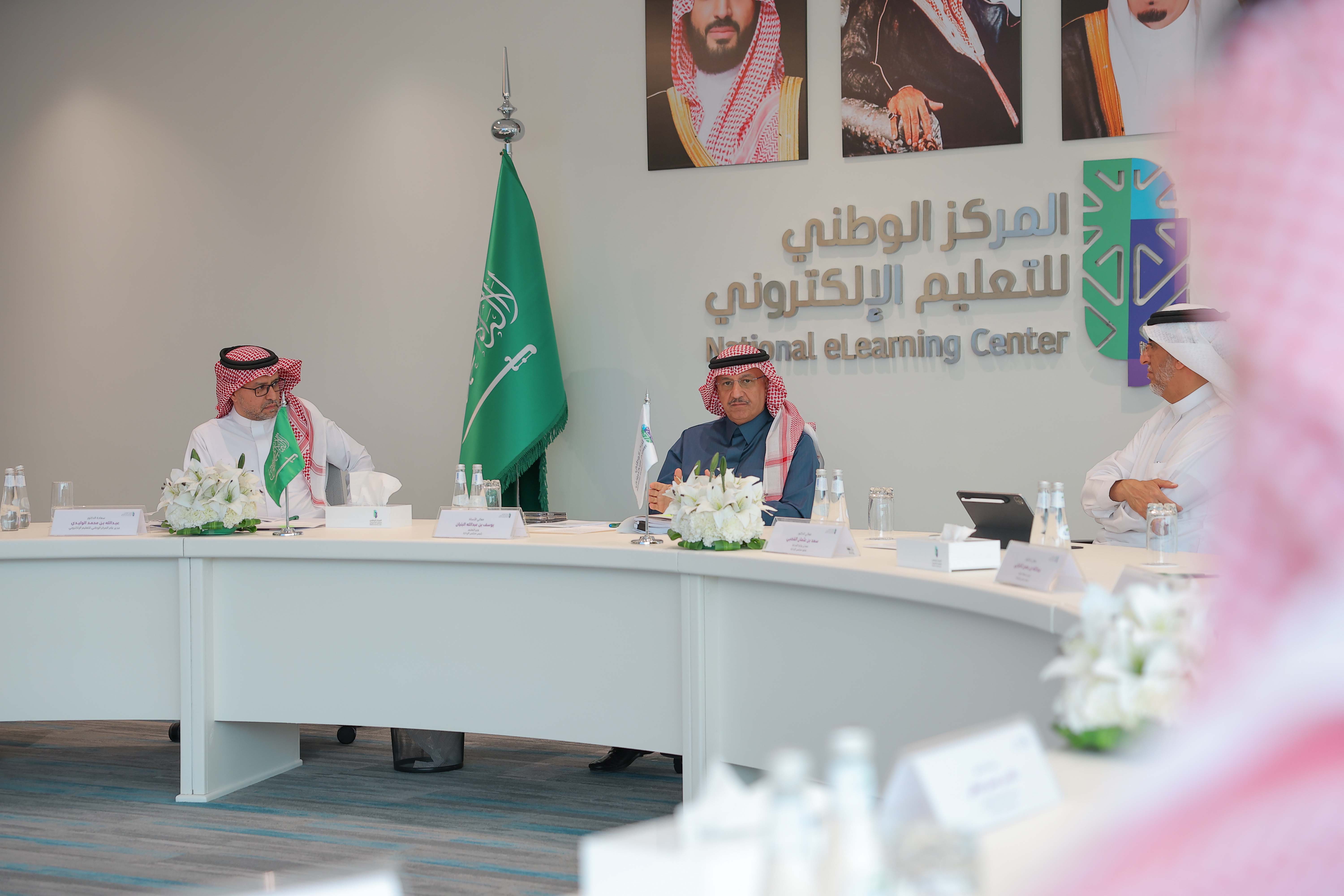 صور من اجتماع مجلس إدارة المركز الخامس عشر، تعكس معالي الأستاذ يوسف البنيان، الدكتور عبدالله الوليدي، الدكتور سعد القصبي، الدكتور صالح الغامدي، الدكتورة نورة المهنا، المهندس عبدالله الدخيل، المهندس أحمد الصويان، المهندس خالد المحيسن، بالإضافة إلى وجود شعار وعلم المركز، علم المملكة، صور لقادة المملكة في الخلف.