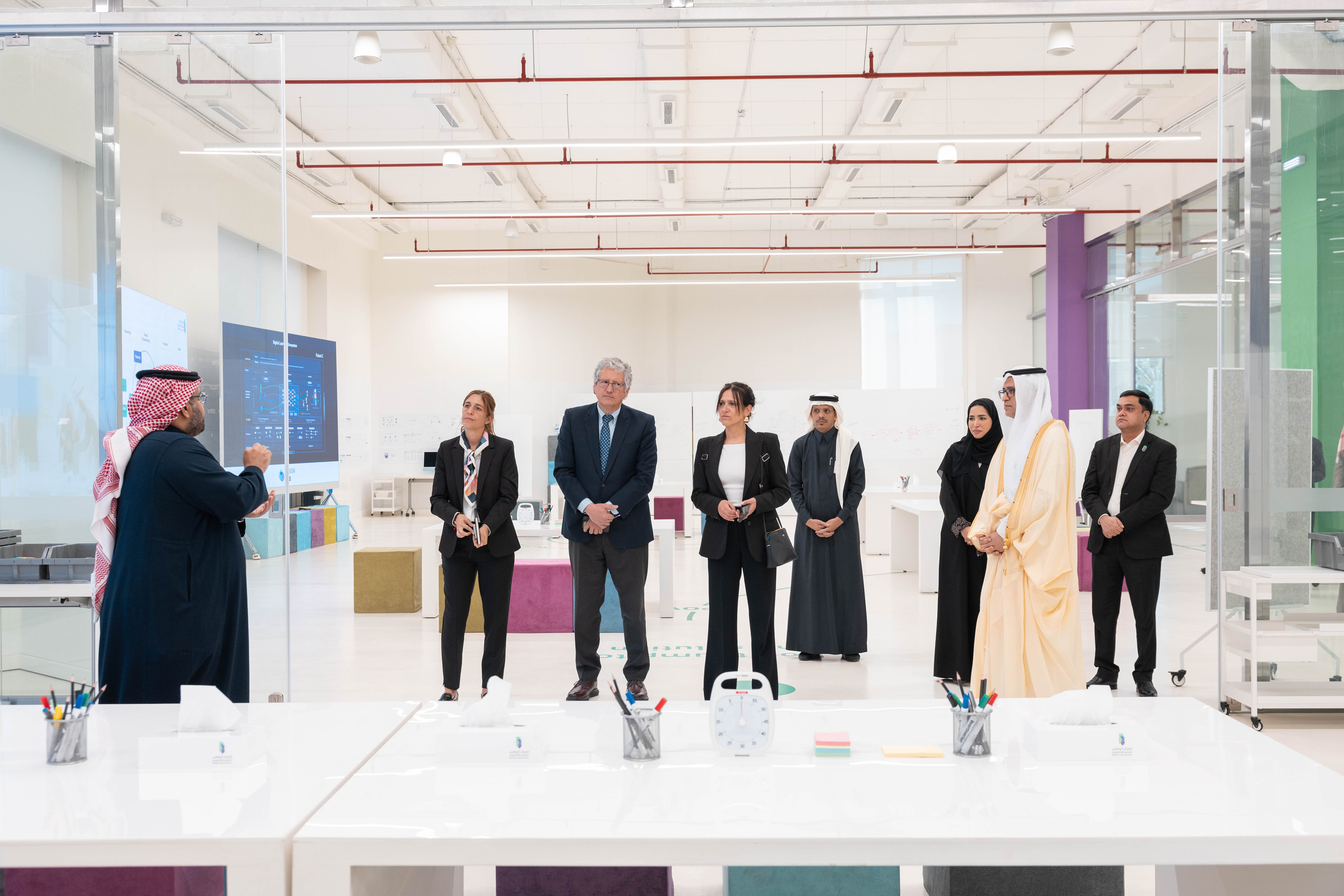 صورة توضح الوفد الزائر من الأرجنتين إلى المركز الوطني للتعليم الإلكتروني، حيث تعكس المدير العام للمركز الدكتور عبدالله الوليدي، وسفير الأرجنتين، إلى جانب 3 رجال، و 3 نساء، من المرافقين.