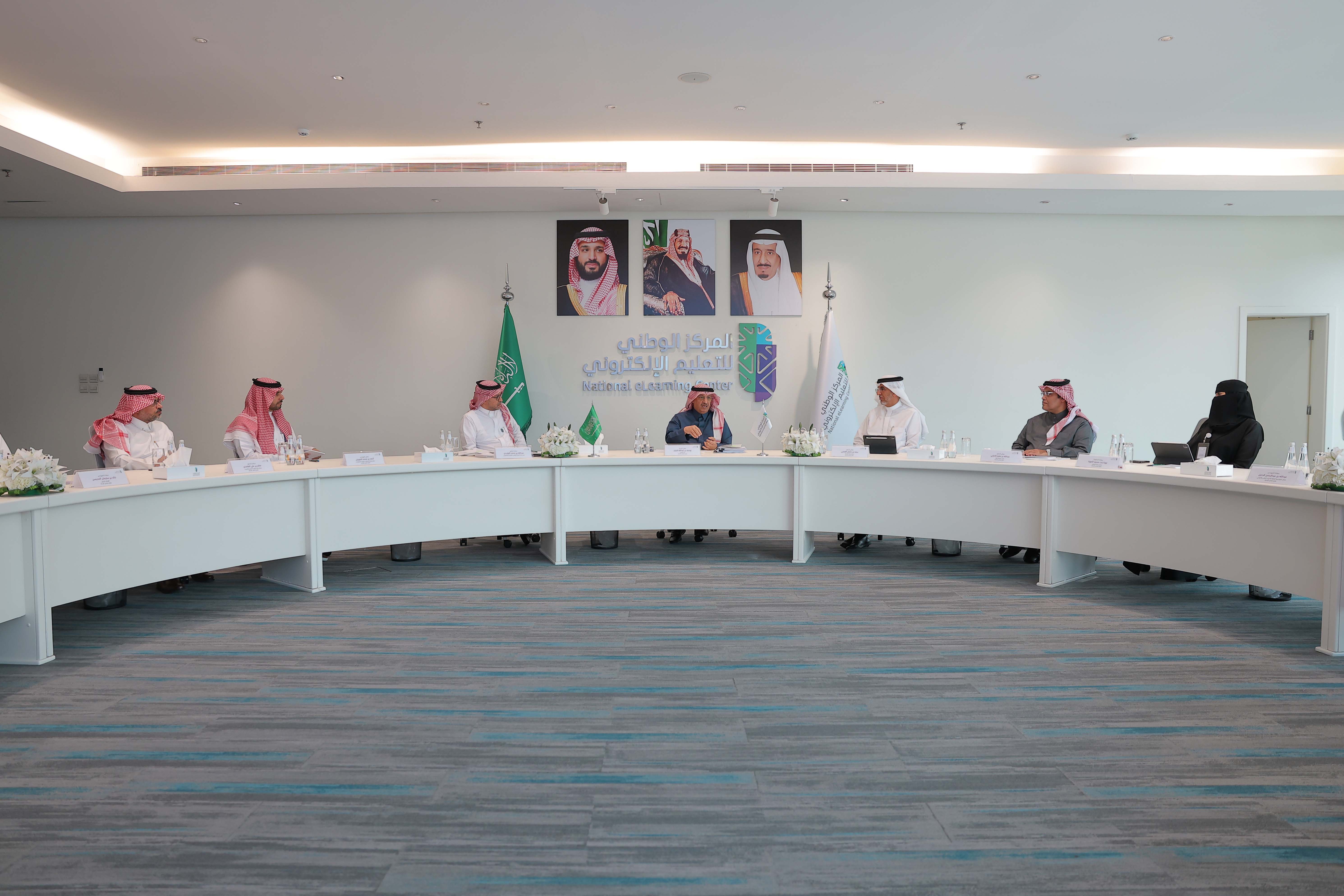 صور من اجتماع مجلس إدارة المركز الخامس عشر، تعكس معالي الأستاذ يوسف البنيان، الدكتور عبدالله الوليدي، الدكتور سعد القصبي، الدكتور صالح الغامدي، الدكتورة نورة المهنا، المهندس عبدالله الدخيل، المهندس أحمد الصويان، المهندس خالد المحيسن، بالإضافة إلى وجود شعار وعلم المركز، علم المملكة، صور لقادة المملكة في الخلف.